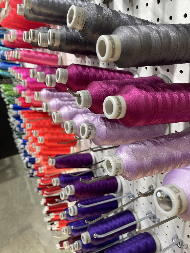 Wall of embroidery thread cones in pinks, purples and greys at the Brooklyn shop